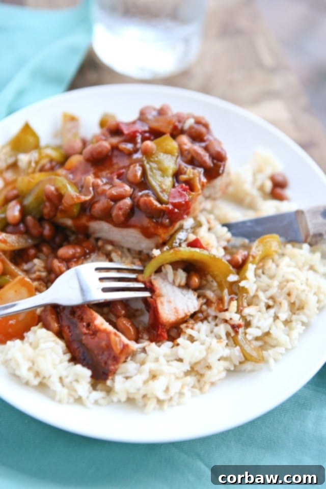 Grilled Pork Chops smothered in a special sauce made with baked beans, peppers and onions. So flavorful and an easy dinner to make - perfect for grilling season! A plate of perfectly grilled pork chops generously topped with the rich, savory, and slightly sweet bean and vegetable smothering sauce. Ready to be served for a delightful family dinner.