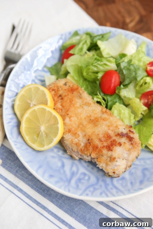 Golden brown Parmesan Baked Pork Chops on a baking sheet, ready to be served – a true family favorite!