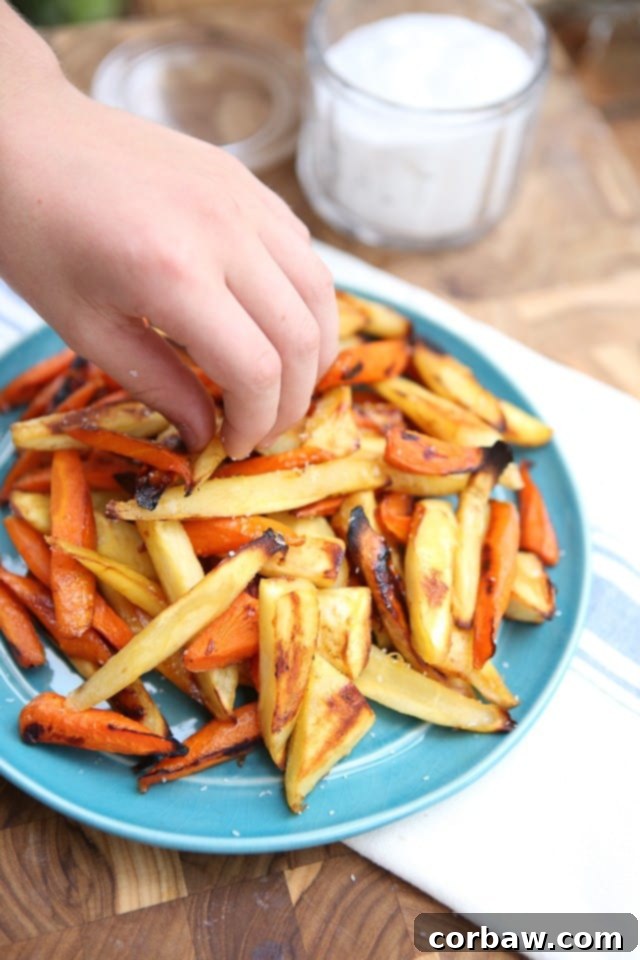 Kids Love These! Perfectly Roasted Parsnips and Carrots Appetizing plate of Honey Roasted Parsnips and Carrots, expertly cut into finger-food sticks, with a focus on their golden-brown edges