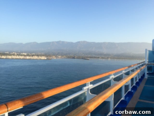 Island View from Cruise Ship A serene view of a tropical island from the deck of a cruise ship, with calm blue waters and lush green hills under a clear sky.