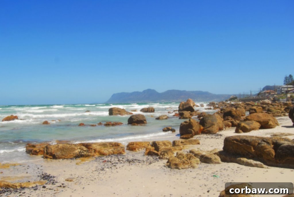 A picturesque view of Muizenberg Beach in Cape Town, South Africa, featuring the iconic colorful bathing boxes