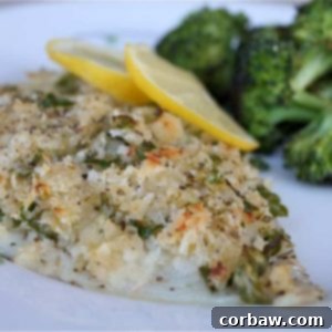 Baked breaded fish on a plate with lemon, showcasing the delicious crispy topping.