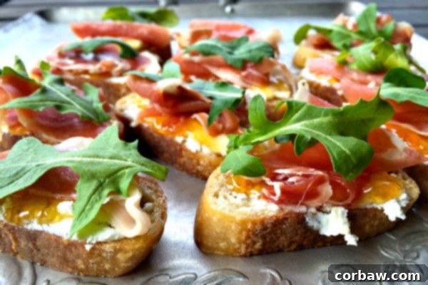 Friday Freedom 6 Prosciutto Goat Cheese Crostini from Reluctant Entertainer - Elegant appetizers with prosciutto, goat cheese, and fresh herbs on toasted bread.