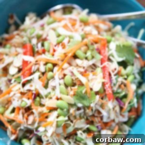 A close-up image of the finished Asian Almond Slaw Salad in a bowl, showcasing its vibrant colors and crunchy texture. A perfect healthy side dish for any gathering.