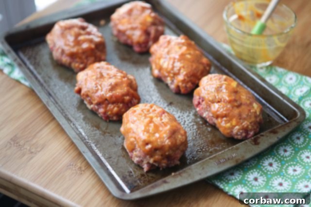 Mini Honey Mustard Meatloaf Recipe Details Close-up of baked Mini Honey Mustard Meatloaf topped with melted cheddar cheese and a golden glaze.