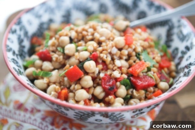 Italian Wheat Berry Salad with Roasted Red Peppers and Garbanzo Beans Close-up of the Italian Wheat Berry Salad, showcasing roasted red peppers, garbanzo beans, and fresh basil, a wholesome and colorful dish.