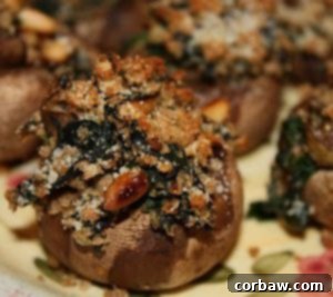 A close-up of a perfectly baked Spinach and Toasted Pine Nut Stuffed Mushroom