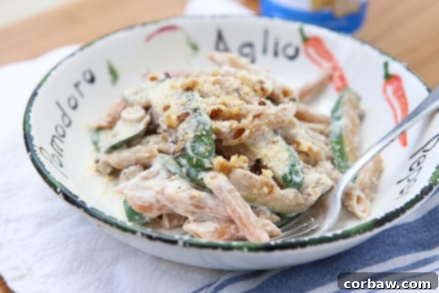 A serving of Whole Wheat Pasta with Ricotta, Zucchini, and Walnuts, garnished with basil, showing its creamy texture and fresh ingredients.