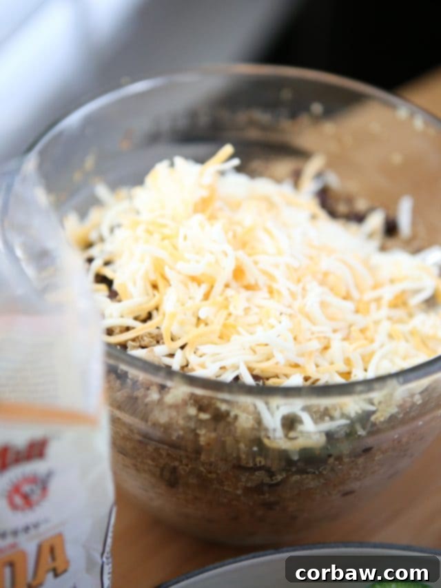 Veggie Enchilada Stuffed Peppers 5 Cooked Bob's Red Mill quinoa and black beans ready to be combined with spices and cheese to create the flavorful filling for the stuffed peppers.