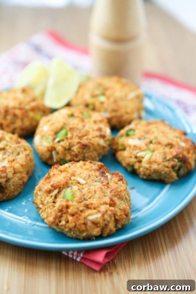 baked salmon cakes on blue plate with pepper mill in the background