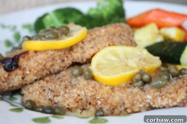 Classic chicken piccata with fresh lemon slices and capers, garnished with parsley, ready to serve.