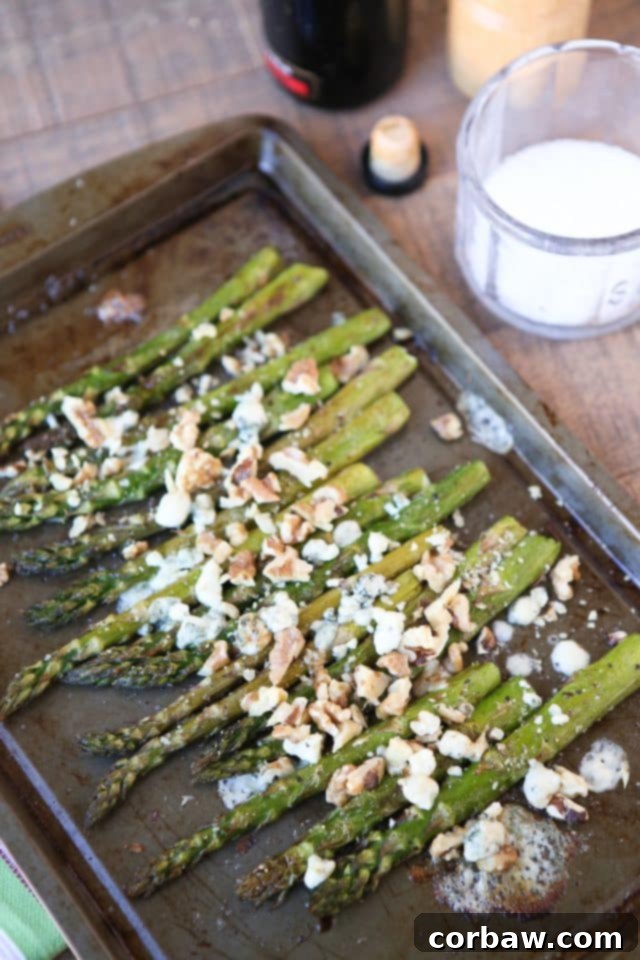 A vibrant platter of Roasted Asparagus with Balsamic, Gorgonzola, and Walnuts.