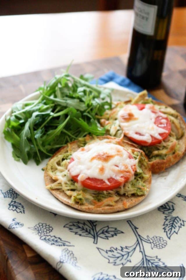 Close-up of a delectable slow cooker pesto chicken melt sandwich, oozing with melted cheese and garnished with fresh basil