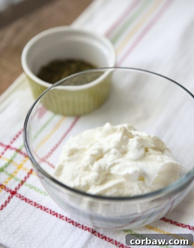 A rustic presentation of Chipotle Ranch Greek Yogurt Dip in a small bowl, surrounded by various fresh vegetables and dippers.