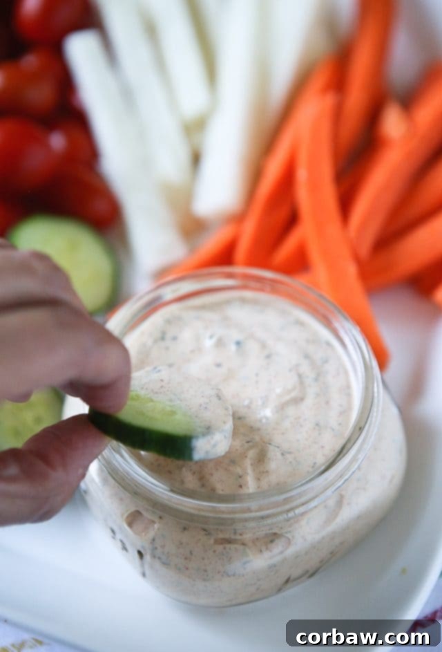 A wide shot of a platter with Chipotle Ranch Greek Yogurt Dip, fresh vegetables, and various dippers, ready for a gathering.