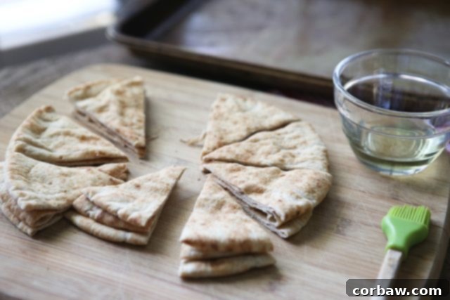 Homemade baked pita chips pita bread cut into triangles on a cutting board