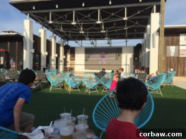 The lively atmosphere of The Hub 30A with outdoor movies and diverse food vendors Families and friends gathering at The Hub on 30A, enjoying outdoor dining and entertainment