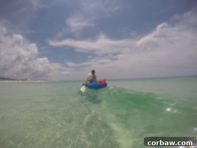 Kayaking adventure on the beautiful coastal dune lakes of 30A, Florida Someone learning to kayak on the clear, calm waters of Big Redfish Lake, 30A
