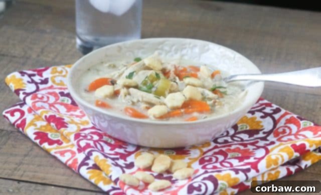 Family-Friendly Creamy Chicken and Wild Rice Soup Meal A serving of Slow Cooker Creamy Chicken and Wild Rice Soup in a rustic bowl, accompanied by crusty bread, ready for a comforting and nutritious family dinner.