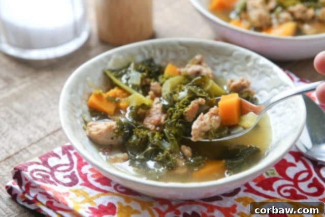 bowl of sausage and kale soup with spoon