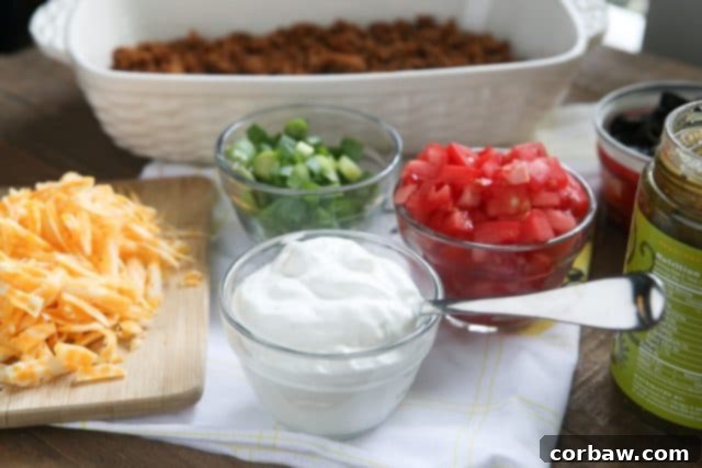 This Layered Taco Dip is full of all the ingredients that we love in our tacos, but in dip form. Great to serve while entertaining family and friends! #UndeniablyDairy #DairyGood #ad