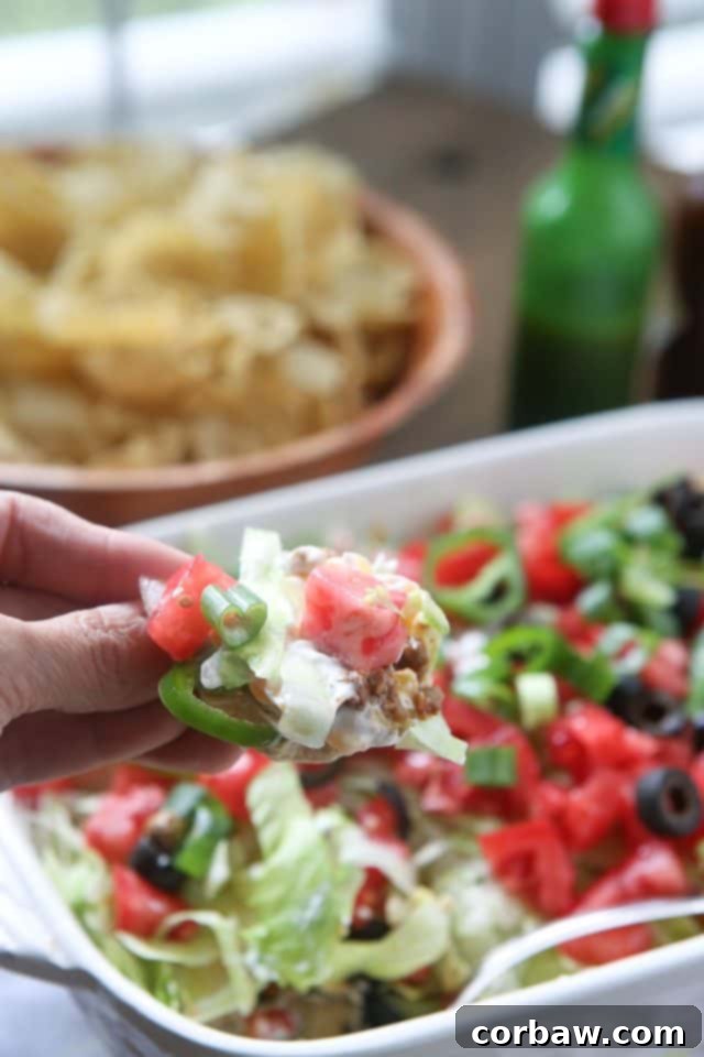 The ultimate Layered Taco Dip, featuring fresh ingredients and creamy dairy goodness, ready to be served at any party.