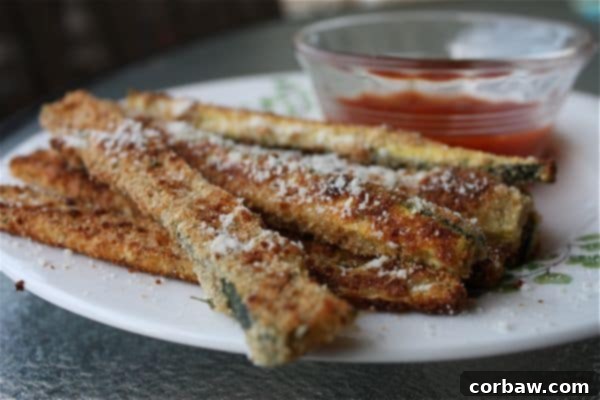 Oven Baked Parmesan Zucchini Sticks: A delightful, healthier alternative to fried zucchini Close-up of golden brown oven baked zucchini sticks with Parmesan cheese, ready to serve.