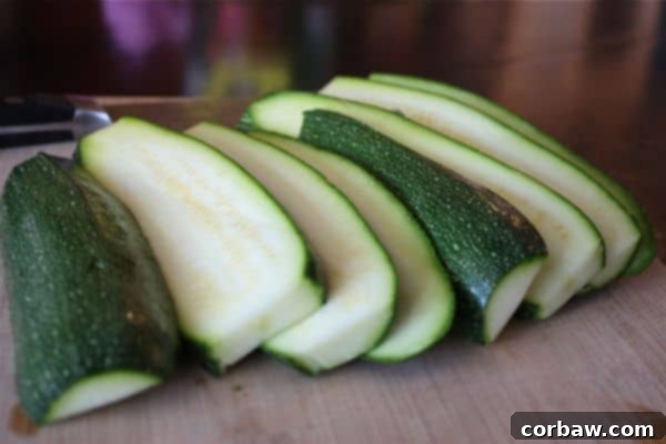 Crispy Parmesan Zucchini Fries 2 A plate of golden brown baked Parmesan zucchini sticks with dipping sauce and fresh herbs.