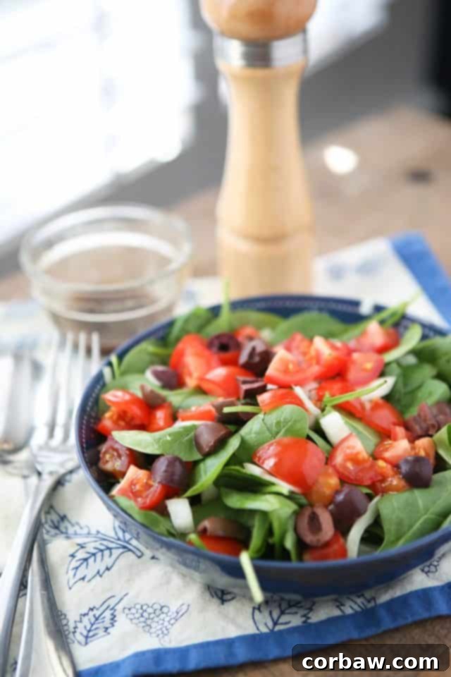 A bowl of fresh chopped tomato and spinach salad, beautifully presented and ready to be enjoyed, showcasing the vibrant colors of summer produce.