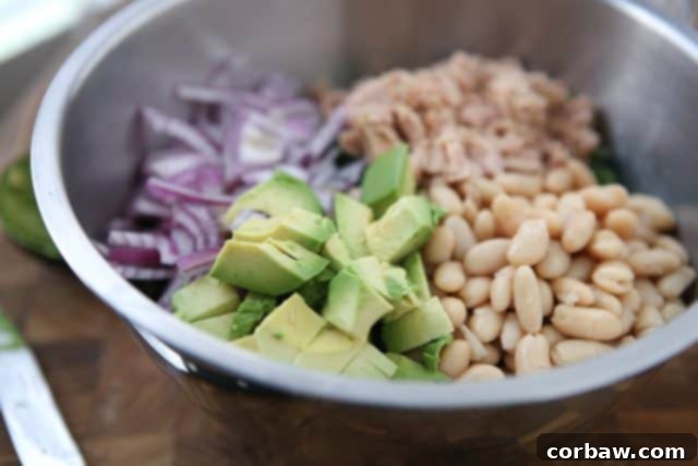 Overhead shot of the Lemony Tuna and White Bean Kale Salad, showcasing the fresh ingredients like kale, white beans, tuna, and avocado. #tuna #kale #salad #avocado #LowCarb #healthymeals