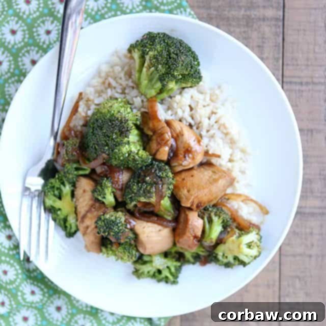 Healthy Chicken and Broccoli Stir Fry white plate with chicken and broccoli stir fry over brown rice