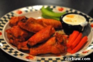 A plate of delicious hot wings, glistening with sauce, paired perfectly with a glass of beer.