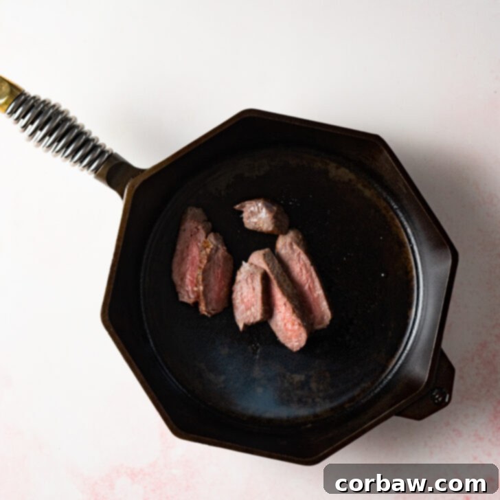 Sliced steak in cast iron skillet