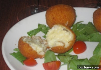 Delicious mozzarella-filled risotto balls (arancini), crispy and golden brown