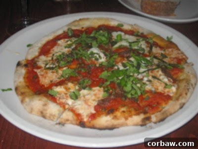 A delectable Pizza Napoletana, fresh from the wood-fired oven, with capers, anchovies, tomatoes, basil and mozzarella