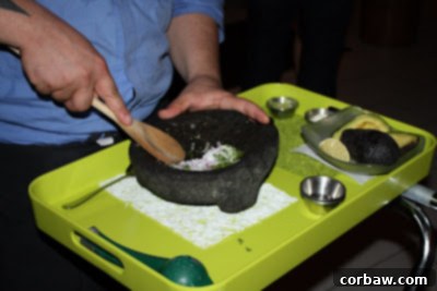 A chef skillfully preparing fresh guacamole tableside at Oyamel restaurant, highlighting the interactive experience