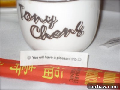 A classic fortune cookie with a positive and hopeful message, resting on a small plate after a meal