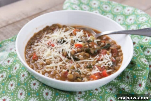 Hearty Italian Tomato Lentil Spinach Soup 6 White bowl on a green napkin filled with hearty Italian lentil and vegetable soup, ready to be enjoyed