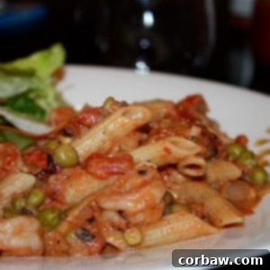 Plate of Creamy Shrimp Pasta with Tomatoes and Peas