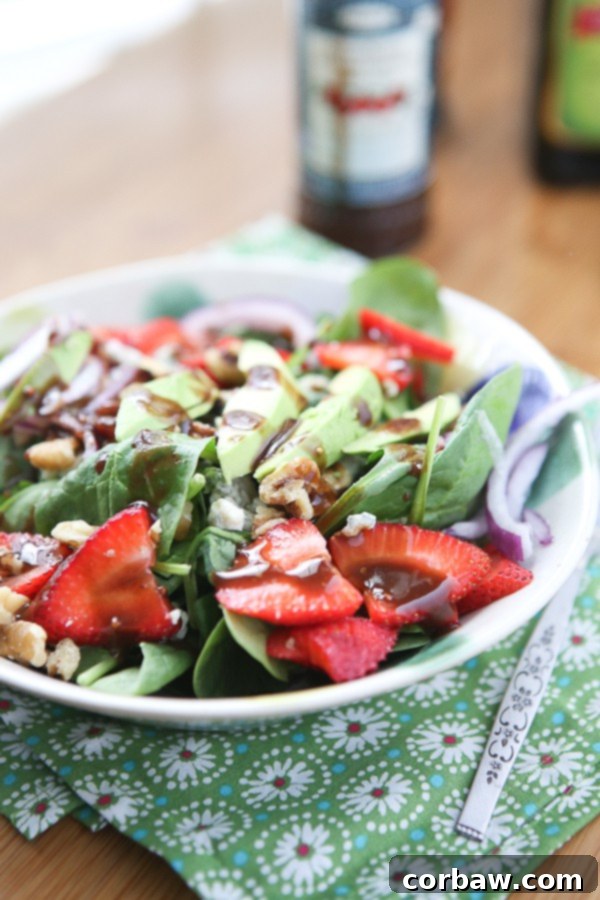 Strawberry Spinach and Walnut Salad with Raspberry Balsamic Vinaigrette A beautiful bowl of fresh spinach salad topped with bright red strawberries, creamy avocado slices, crunchy walnuts, and drizzled with a homemade raspberry balsamic vinaigrette dressing.