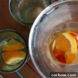 A glass of white sangria with fresh fruit garnish.