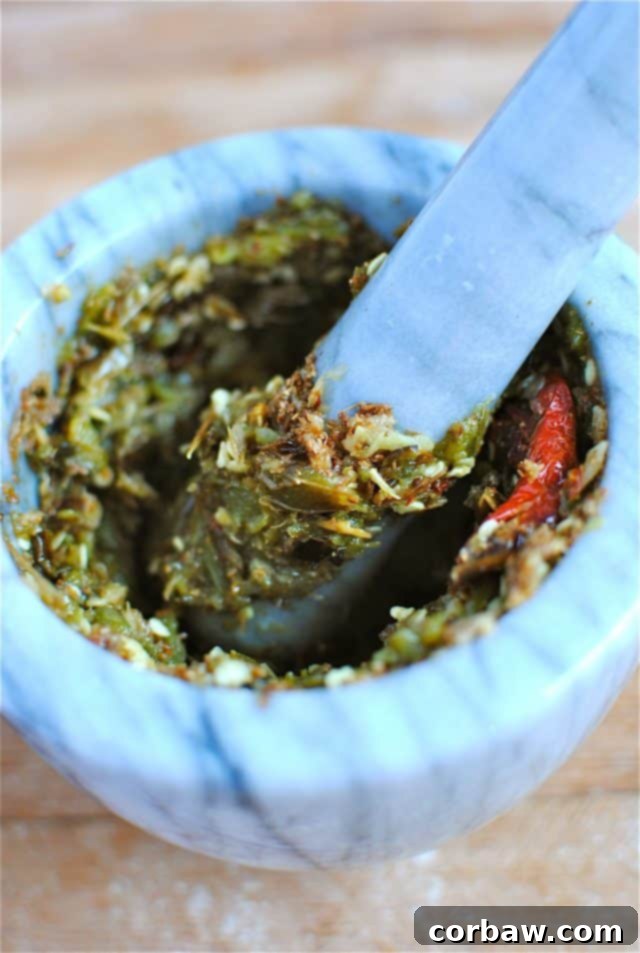 Richly spiced paste forming in a mortar with cumin, coriander, peppers, and garlic