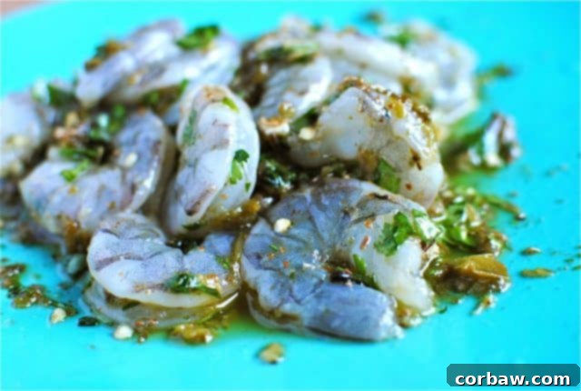Raw shrimp marinating in a fiery spice blend before cooking