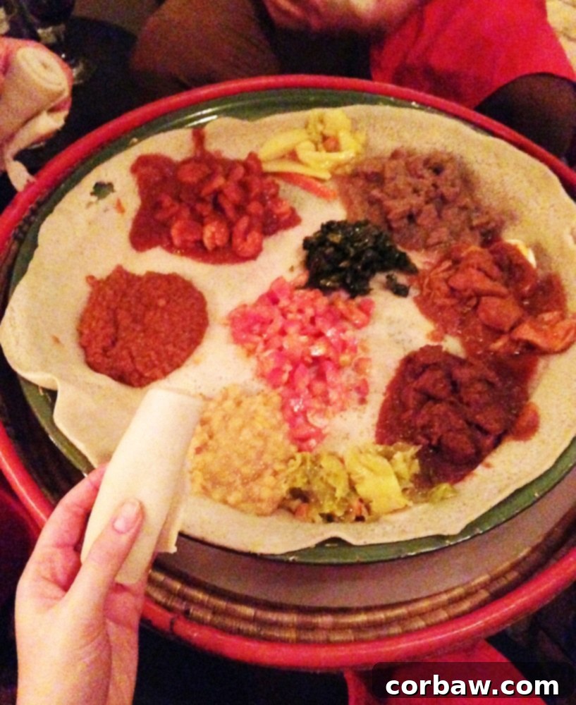 A large platter of various Ethiopian stews and dishes served on injera bread.