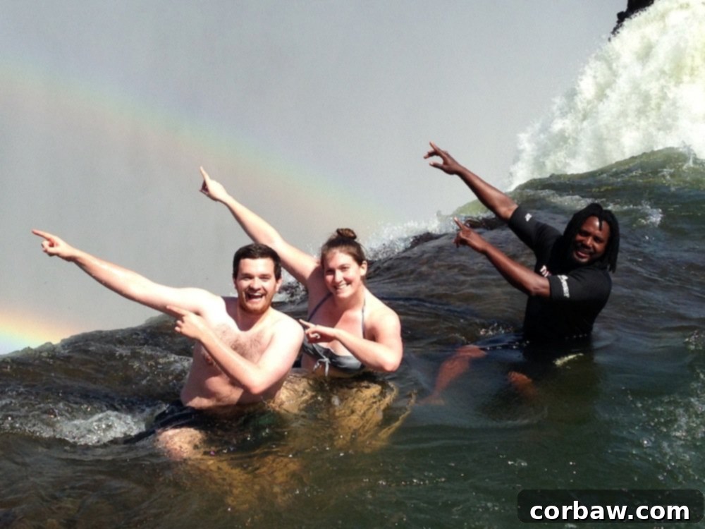 Author and fiancé with their guide in Devil's Pool, at the breathtaking edge of Victoria Falls.