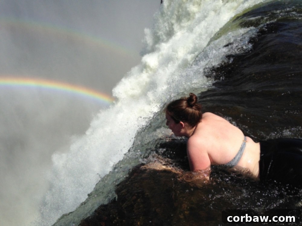 Author looking over the edge of Devil's Pool into the Victoria Falls gorge, a mix of fear and wonder.