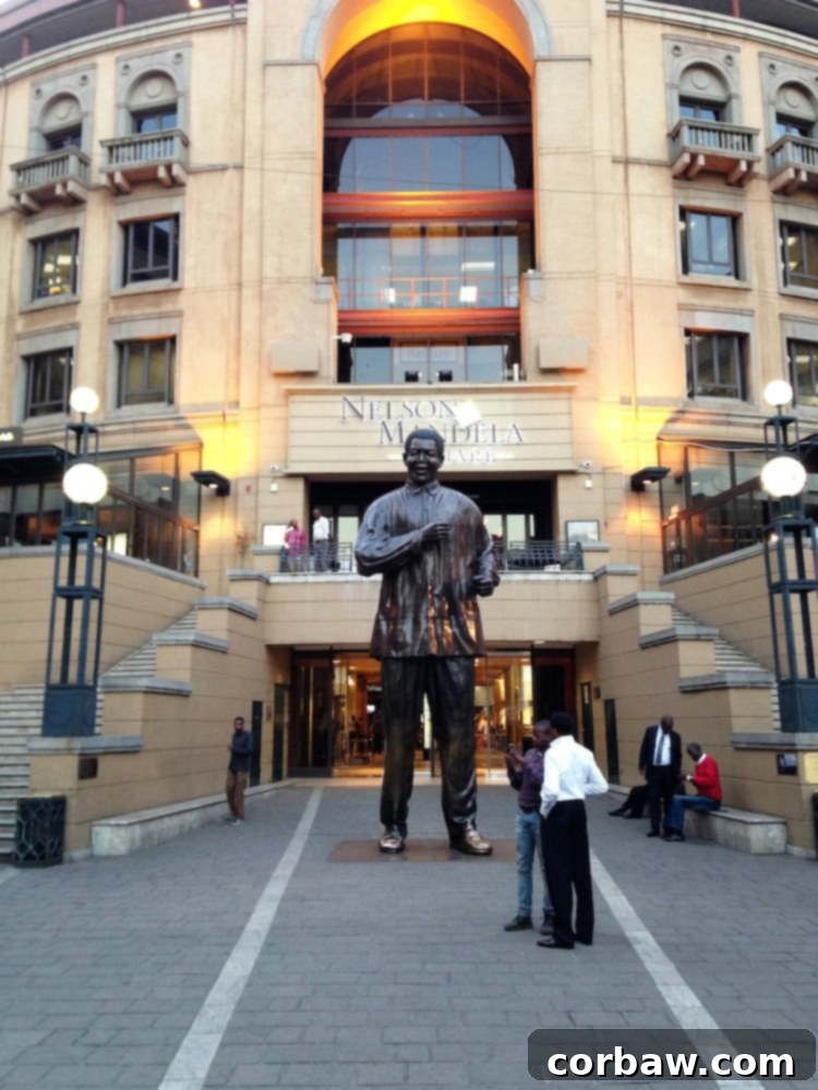 Nelson Mandela statue at Mandela Square in Sandton, Johannesburg, surrounded by shops and restaurants.