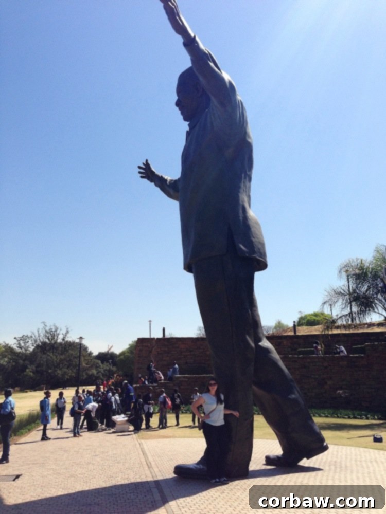Woman posing next to the base of the giant Nelson Mandela statue