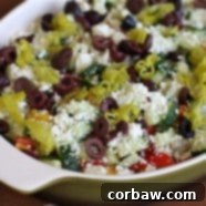 Layered Greek Hummus Dip, a perfect Mediterranean appetizer for parties and gatherings.