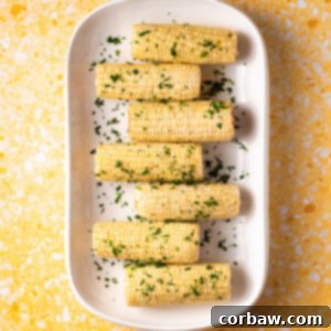 Mastering Steak Sides: 20+ Perfect Pairings and Pitfalls 18 Buttery Sous Vide Corn on the Cob on a white platter, ready to serve.